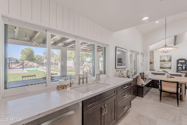 2724 W Colt Rd, Chandler, AZ 85224 - kitchen featuring a sink, dark brown cabinetry, hanging light fixtures, light stone counters, and a chandelier