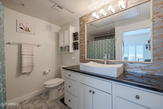 bathroom featuring a textured ceiling, toilet, vanity, and tasteful backsplash