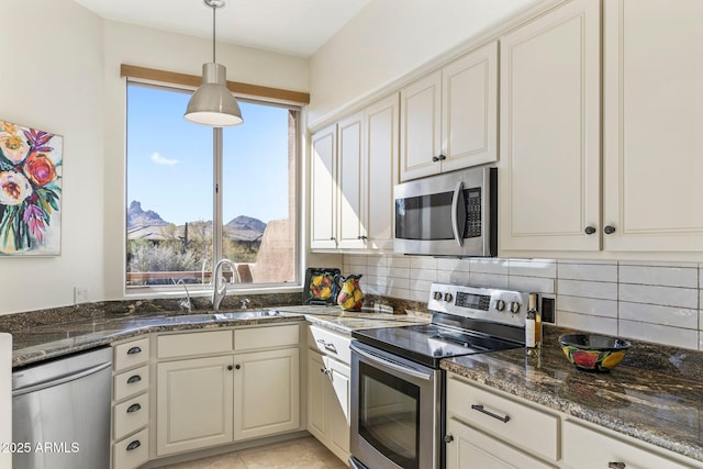 kitchen featuring stainless steel appliances, a mountain view, hanging light fixtures, and backsplash