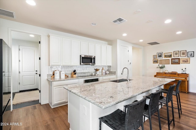 6954 W Maya Way, Peoria, AZ 85383 - kitchen with stainless steel microwave, dark wood-type flooring, recessed lighting, and white cabinets