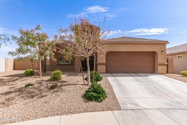 view of front of home with a tiled roof, a garage, stucco siding, fence, and concrete driveway