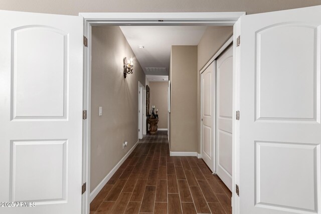 hall featuring baseboards and dark wood-style floors