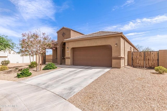 view of front of house featuring fence, a tile roof, a gate, a garage, and driveway