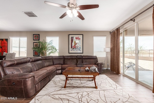 living room with visible vents, ceiling fan, and wood finished floors