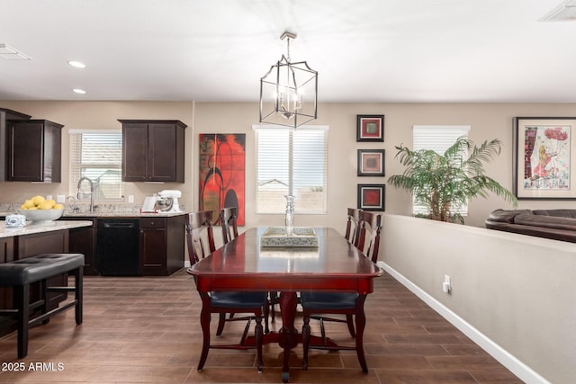 dining area featuring a chandelier, visible vents, baseboards, and wood tiled floor