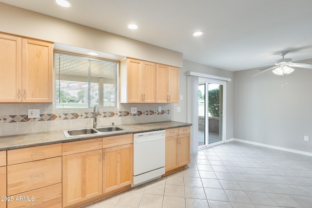 kitchen featuring white dishwasher, light brown cabinets, a sink, a healthy amount of sunlight, and tasteful backsplash