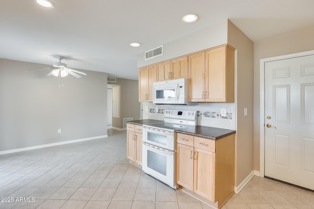 kitchen with dark countertops, visible vents, backsplash, light brown cabinetry, and white appliances