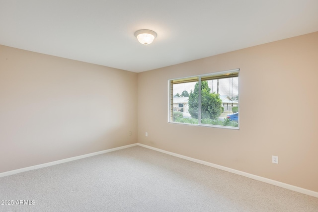 carpeted spare room with baseboards