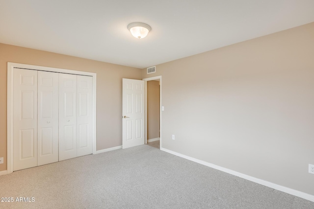 unfurnished bedroom with baseboards, a closet, visible vents, and carpet flooring