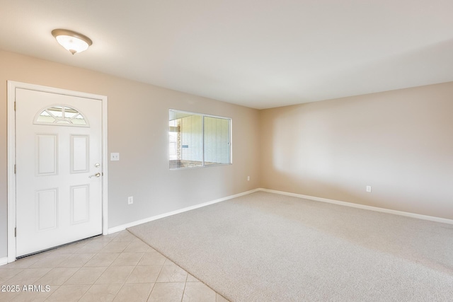 entryway with light carpet, baseboards, and light tile patterned floors