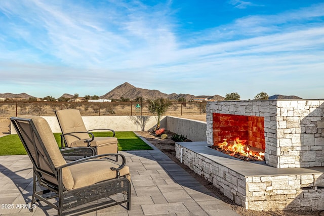 view of patio / terrace with a mountain view and an outdoor stone fireplace