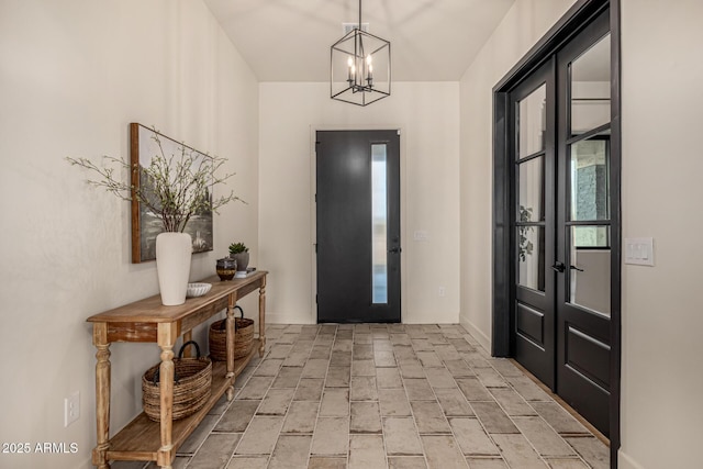 foyer entrance featuring plenty of natural light and a notable chandelier