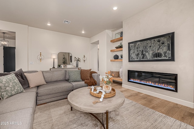 living room featuring an inviting chandelier and light hardwood / wood-style flooring