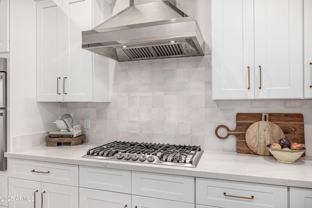 kitchen featuring extractor fan, backsplash, stainless steel gas stovetop, and white cabinets