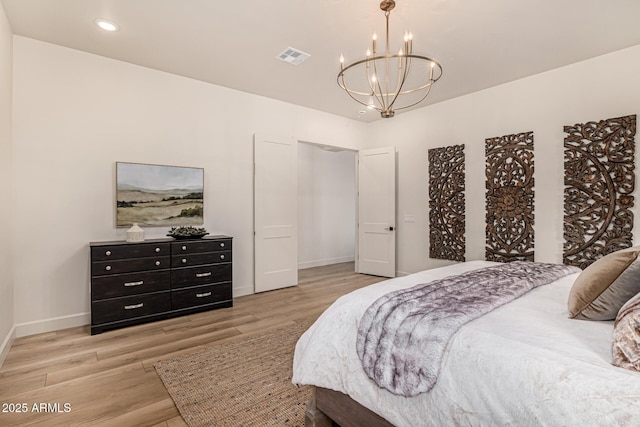 bedroom featuring a notable chandelier and light wood-type flooring