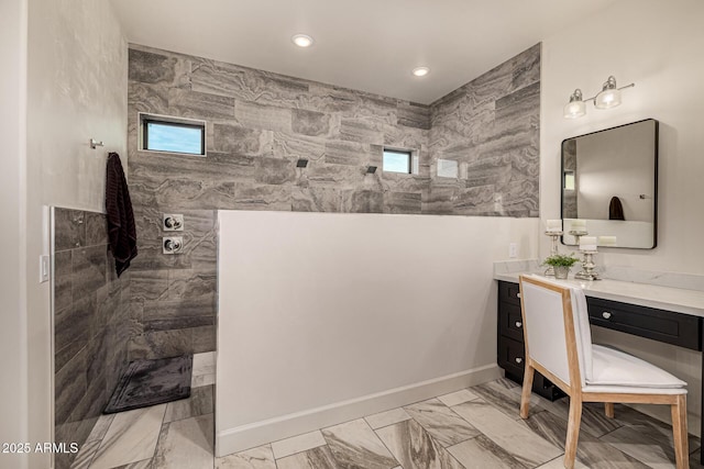 bathroom with vanity and a tile shower