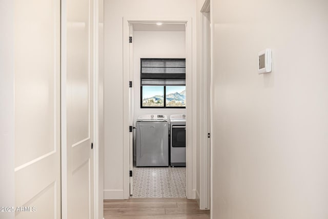 hallway with washer and dryer and light hardwood / wood-style floors