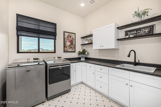 laundry room featuring cabinets, sink, and independent washer and dryer