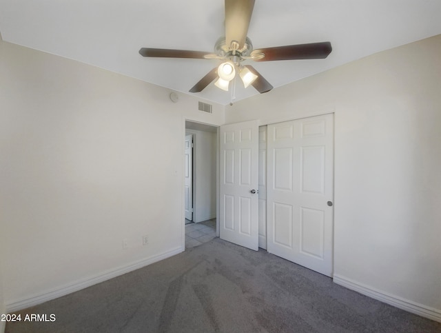 unfurnished bedroom with a closet, light colored carpet, and ceiling fan