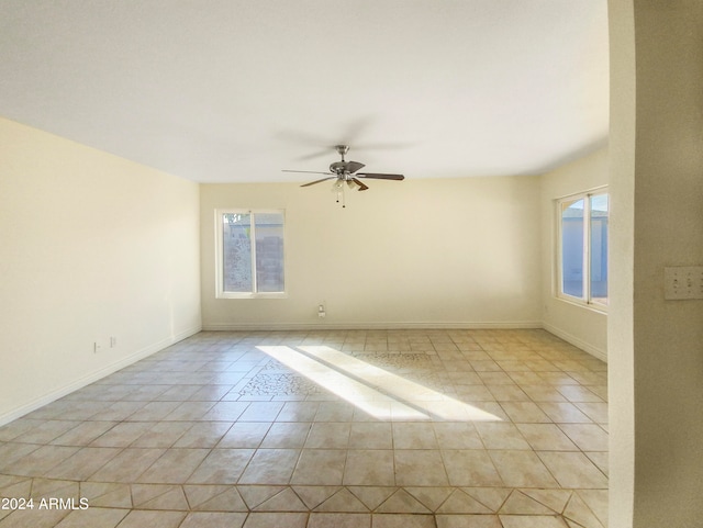 empty room with ceiling fan and light tile patterned floors