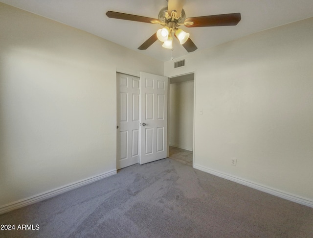 unfurnished bedroom featuring light colored carpet, a closet, and ceiling fan