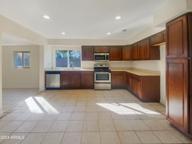 kitchen with sink, stainless steel appliances, and light tile patterned floors