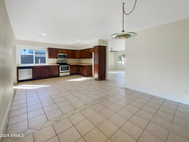 kitchen with appliances with stainless steel finishes, ceiling fan, sink, and light tile patterned floors