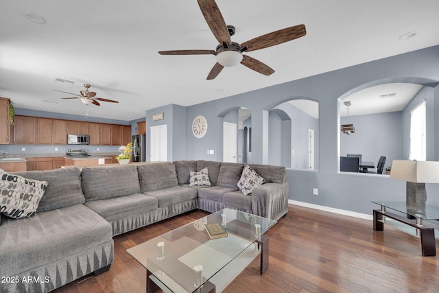 living room featuring ceiling fan and dark hardwood / wood-style floors