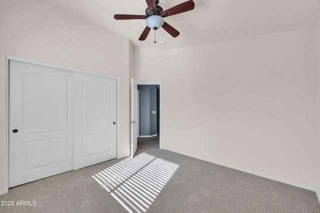 unfurnished bedroom with ceiling fan, a closet, and light carpet