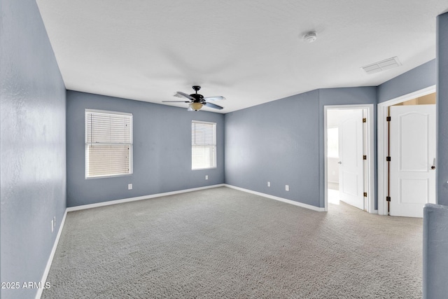 carpeted spare room featuring ceiling fan