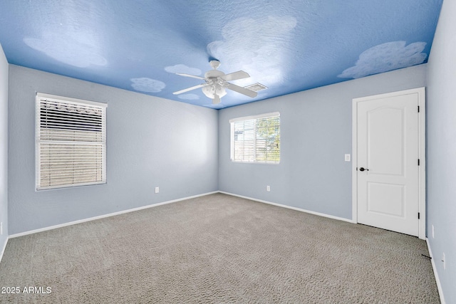 carpeted spare room featuring ceiling fan and a textured ceiling