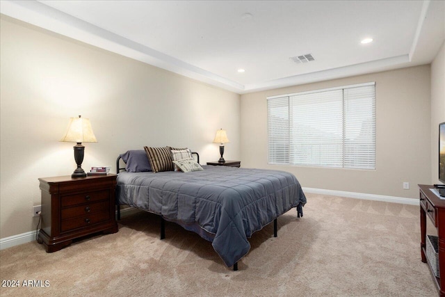 carpeted bedroom with a tray ceiling