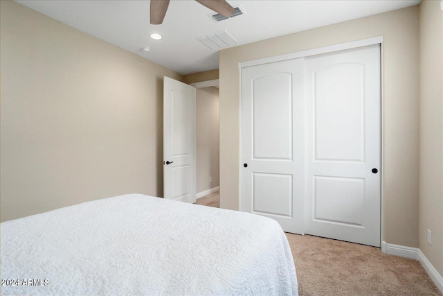 bedroom featuring light carpet, a closet, and ceiling fan