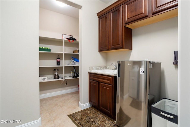 laundry room featuring light tile floors and sink