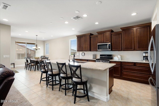 kitchen with sink, stainless steel appliances, plenty of natural light, and a chandelier