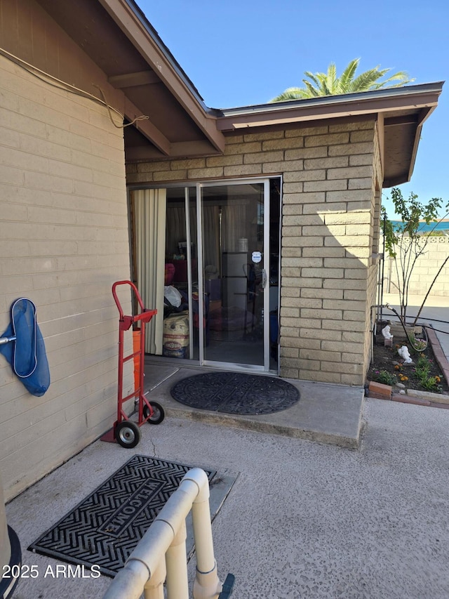 doorway to property featuring brick siding