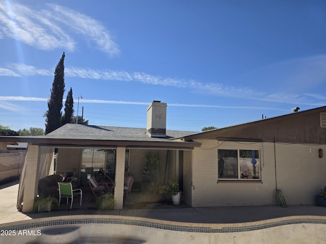 exterior space with a chimney and a patio area