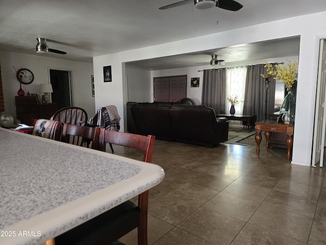 dining area with dark tile patterned flooring and ceiling fan