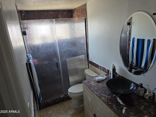 bathroom with vanity, tile patterned floors, a shower stall, and toilet