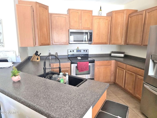 44583 W Sandstone Dr, Maricopa, AZ 85139 - kitchen with appliances with stainless steel finishes, dark countertops, a peninsula, and light tile patterned floors