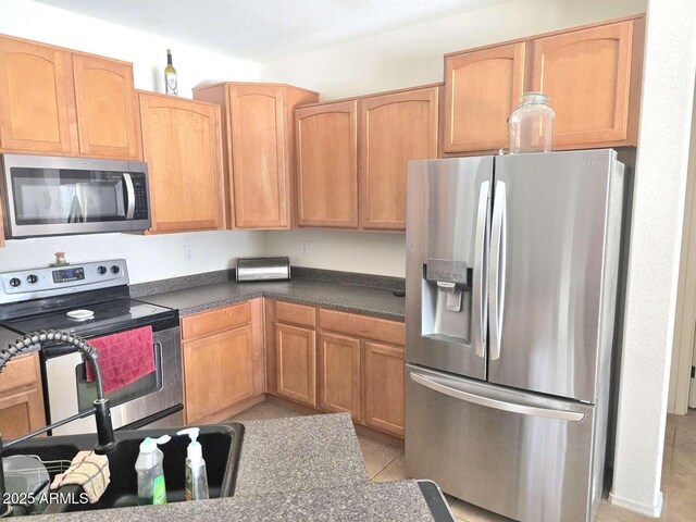 44583 W Sandstone Dr, Maricopa, AZ 85139 - kitchen featuring appliances with stainless steel finishes, dark countertops, and light tile patterned floors