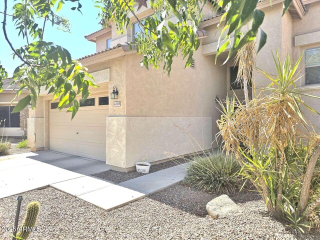 44583 W Sandstone Dr, Maricopa, AZ 85139 - view of home's exterior with stucco siding, a garage, and driveway
