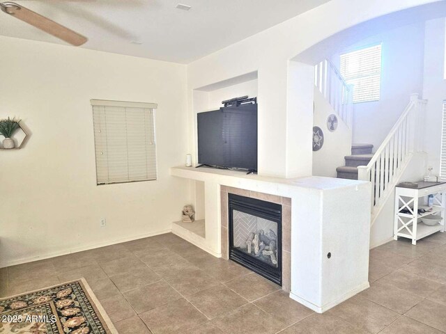 44583 W Sandstone Dr, Maricopa, AZ 85139 - unfurnished living room featuring stairway, tile patterned floors, and a tiled fireplace