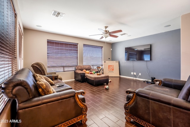 living room with ceiling fan, dark wood-type flooring, and a healthy amount of sunlight