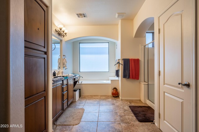 bathroom featuring tile patterned flooring, separate shower and tub, and vanity