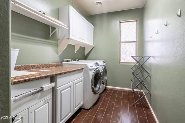 clothes washing area with a healthy amount of sunlight, separate washer and dryer, and cabinets