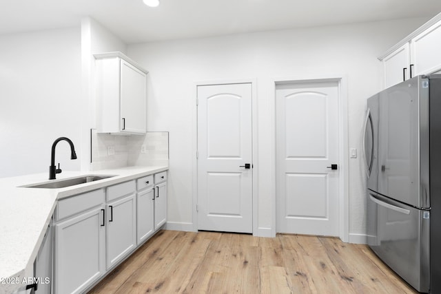 laundry room with sink and light hardwood / wood-style flooring