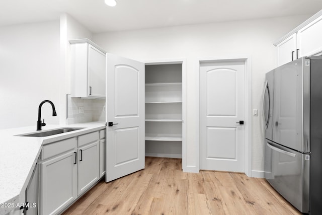 laundry room featuring sink and light hardwood / wood-style flooring