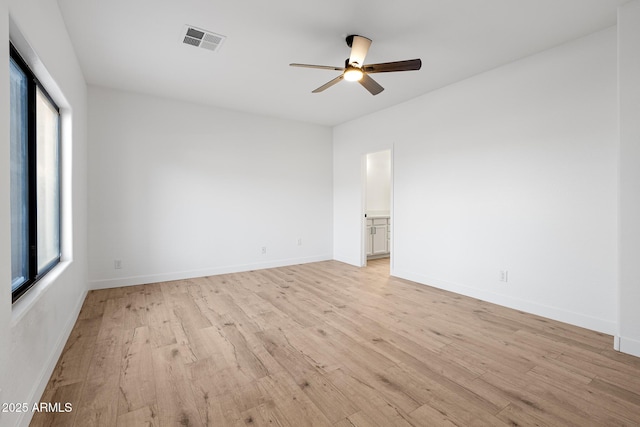 empty room with light wood-type flooring, ceiling fan, and a wealth of natural light