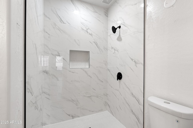 bathroom featuring toilet and tiled shower